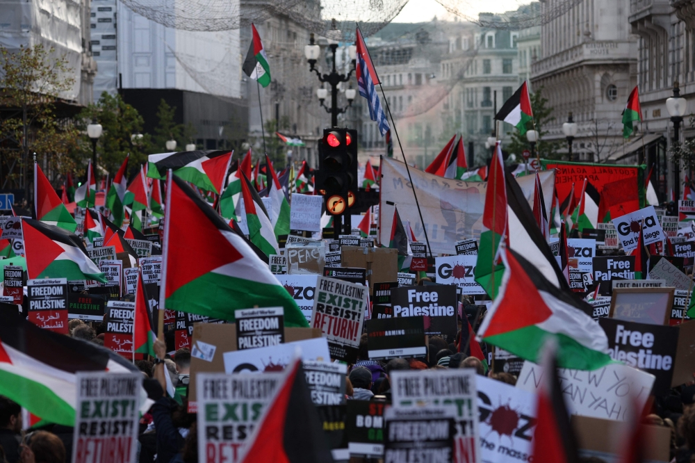People holding placards and flags of Palestine take part in a 'March For Palestine’, part of a pro-Palestinian national demonstration, in London on October 14, 2023, organised by Palestine Solidarity Campaign, Friends of Al-Aqsa, Stop the War Coalition, Muslim Association of Britain, Palestinian Forum in Britain and CND. — AFP pic