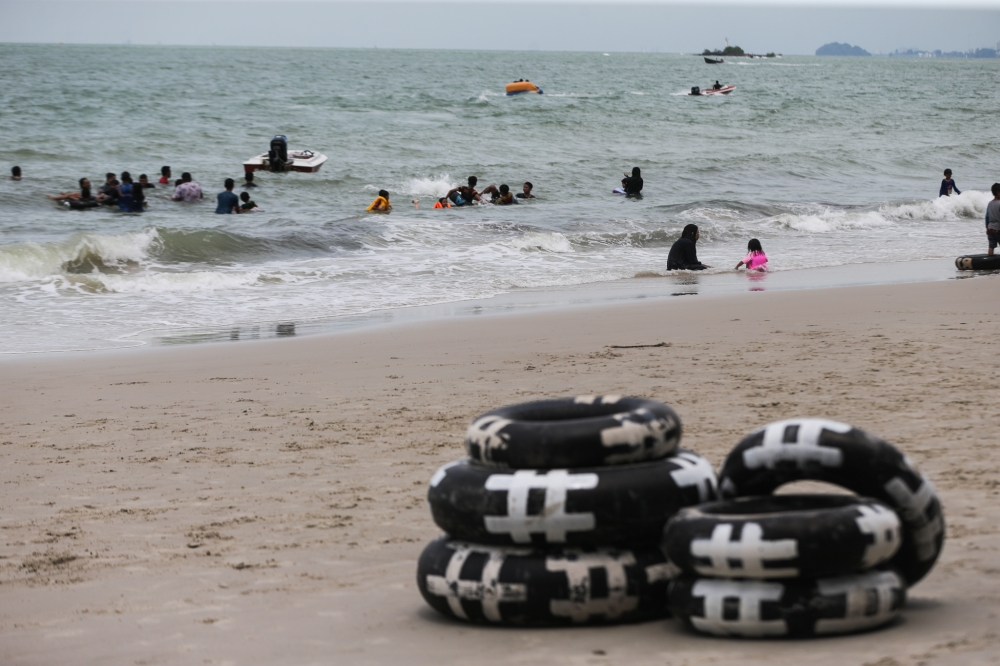 File picture of tourists at the Teluk Kemang beach in Port Dickson. — Picture by Ahmad Zamzahuri