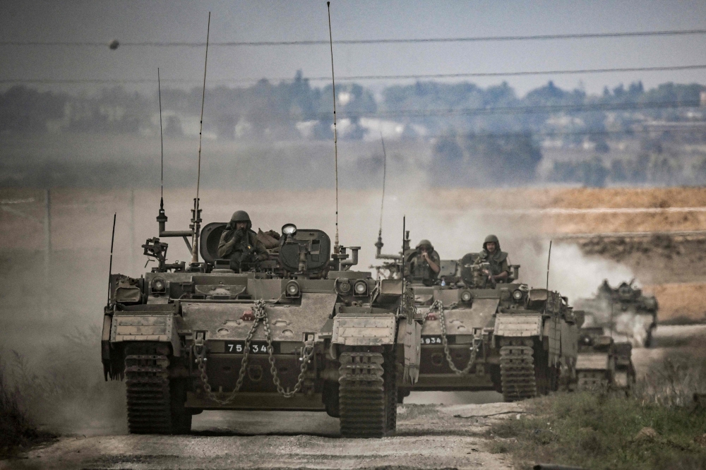A column of Israeli army military armoured vehicles moves near the Gaza border in southern Israel. — AFP pic