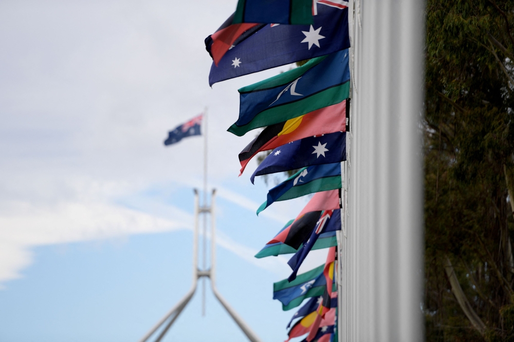 Australian Aboriginal and Torres Strait Island flags are pictured in front of the Parliament House, during the ‘Voice to Parliament’ referendum in Canberra, Australia. — Reuters pic