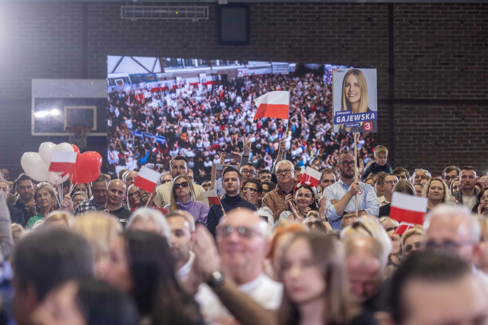 Supporters of the main opposition party Civic Coalition (Koalicja Obywatelska) wave polish flags as they wait for the start of a rally in Pruszkow, Poland on October 13, 2023. — AFP pic
