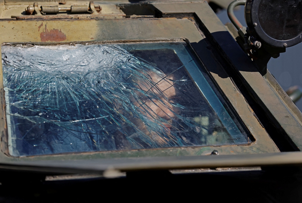 A man sits inside a military vehicle at an exhibition of Ukrainian military equipment captured in the course of Russia-Ukraine conflict, at the station square in Luhansk, Russian-controlled Ukraine, October 15, 2023. — Reuters pic