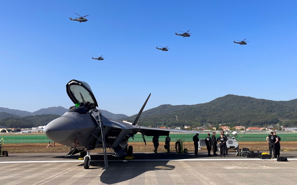South Korean helicopters fly over a US F-22 fighter jet on display at the 2023 Seoul International Aerospace and Defence Exhibition (ADEX) in Seongnam, South Korea. — Reuters pic