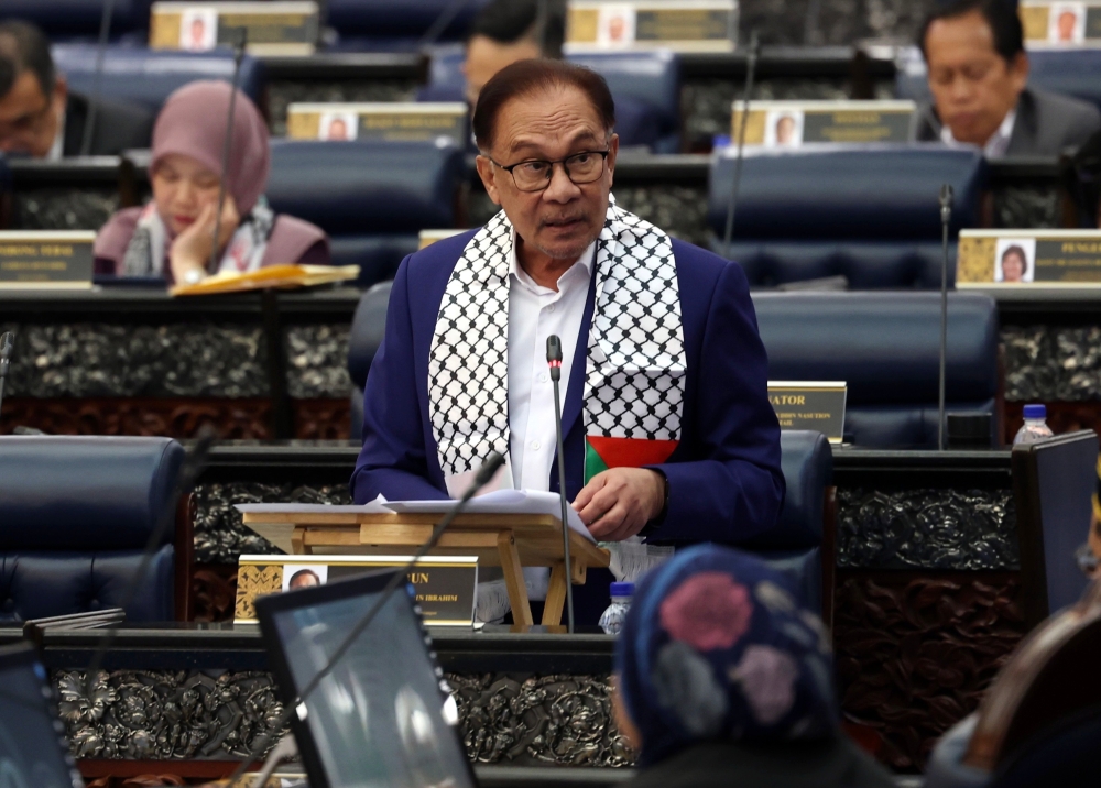 Prime Minister Anwar Ibrahim, wearing a Palestinian scarf, speaks in Parliament October 16, 2023. — Bernama pic