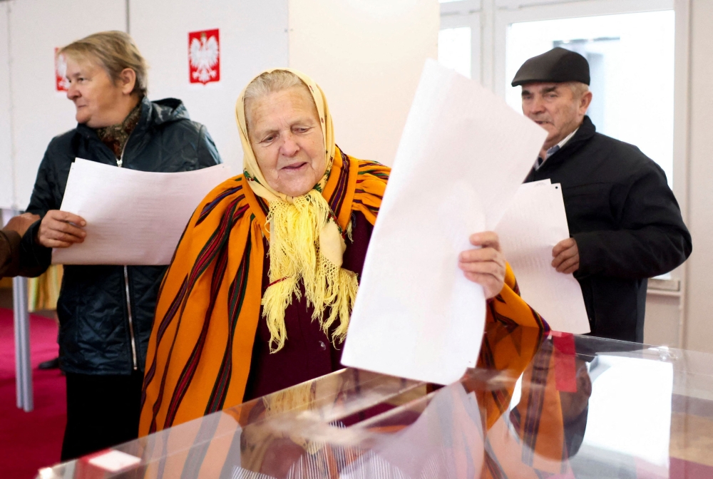 A woman votes during Poland's parliamentary election at a polling station in the village of Gluchow, Poland, October 15, 2023. — Reuters pic