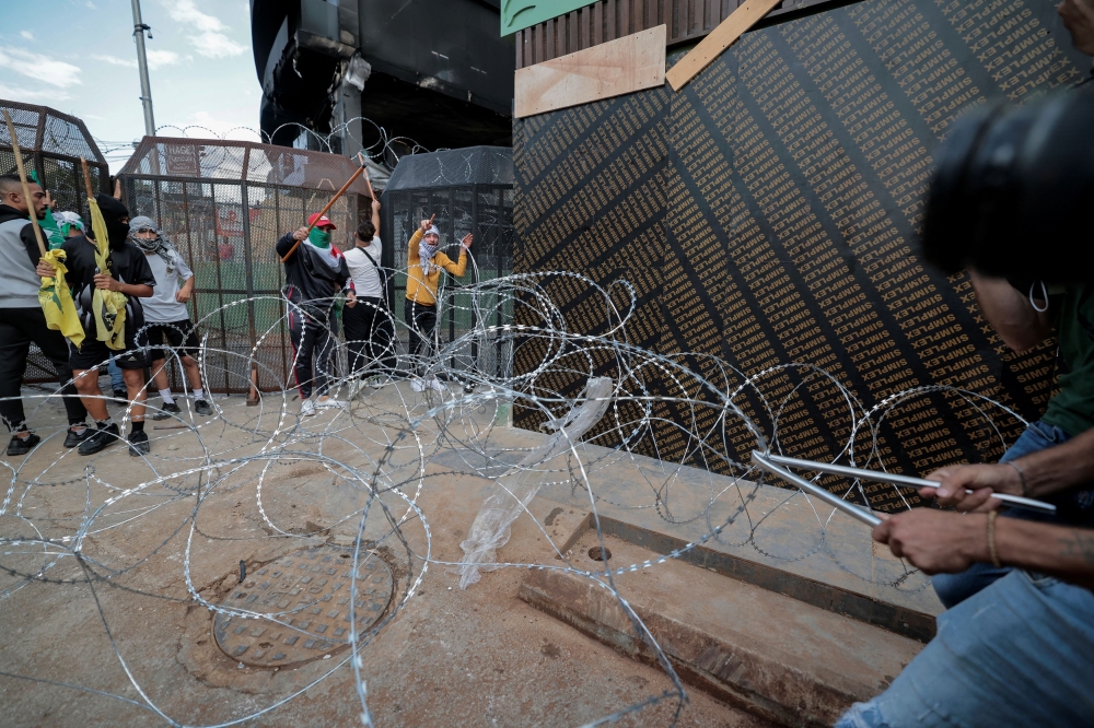 Demonstrators try to pull away razor wire preventing them from approaching the US embassy in Awkar, a suburb of Beirut, after hundreds of Palestinians were killed in a blast at Al-Ahli hospital in Gaza, which Israeli and Palestinian officials blame on each other, Lebanon October 18, 2023. — Reuters pic
