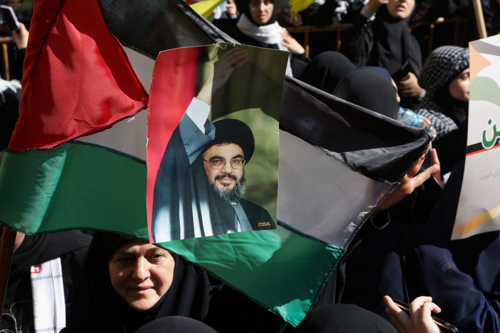 A Hezbollah supporter carries a banner depicting Hezbollah senior official Sayyed Hashem Safieddine during a protest, after hundreds of Palestinians were killed in a blast at Al-Ahli hospital in Gaza that Israeli and Palestinian officials blamed on each other, in Beirut's southern suburbs. — Reuters pic