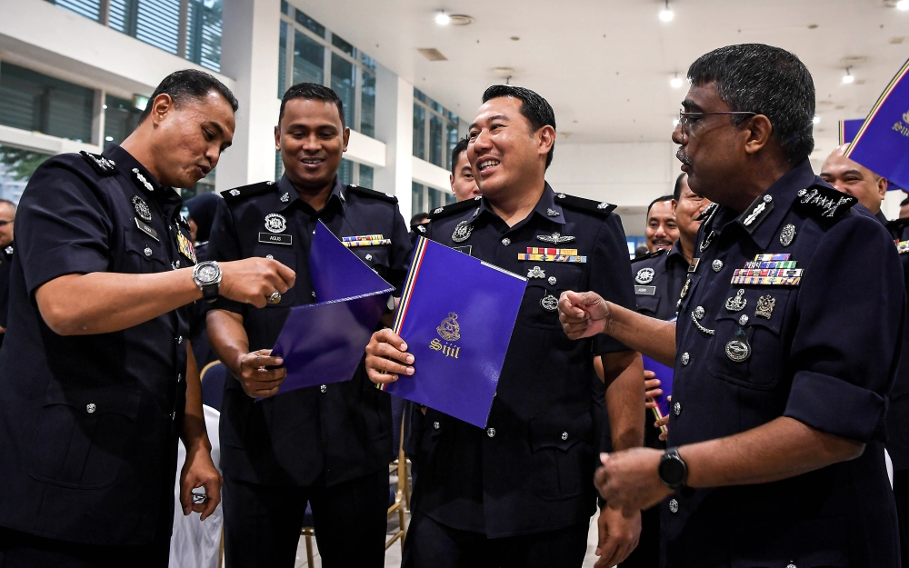 Kuala Lumpur police chief Datuk Allaudeen Abdul Majid pinned the ranks on 12 officers who were promoted to Deputy Superintendent of Police (DSP) and 32 officers promoted to Assistant Superintendent of Police (ASP). — Bernama pic