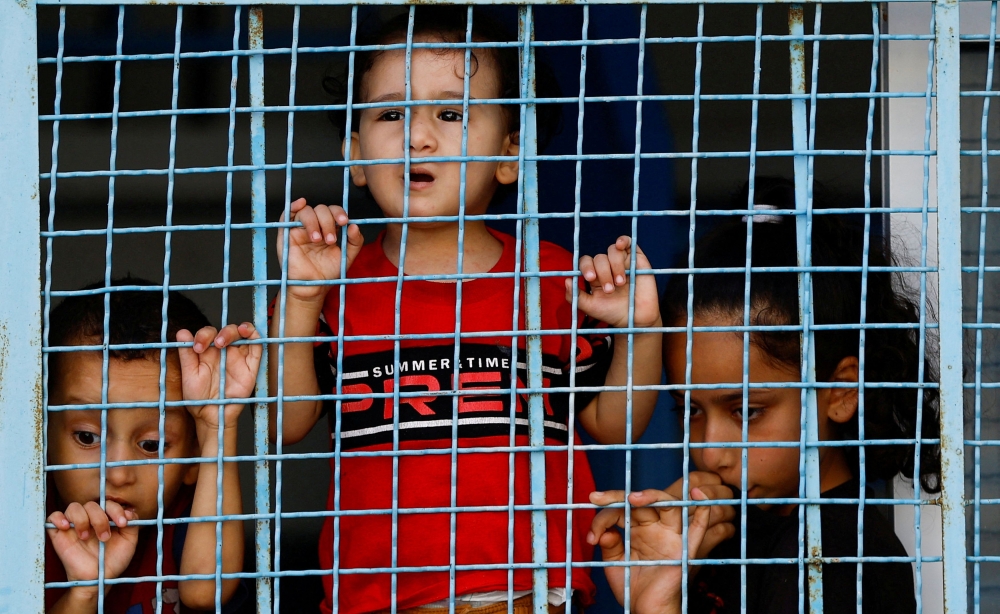 Palestinian children shelter at a United Nations-run centre after Israel’s call for more than one million civilians in northern Gaza to move south. — Reuters pic