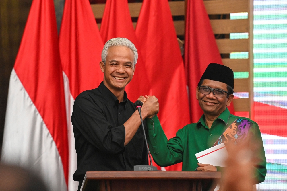 Ganjar Pranowo, presidential candidate of the ruling Indonesian Democratic Party-Struggle (PDI-P), poses for photographs with his running mate, Mohammad Mahfud Mahmodin, chief security minister, known as Mahfud MD, during their declaration in Jakarta. — Reuters pic/Antara Foto/M Risyal Hidayat