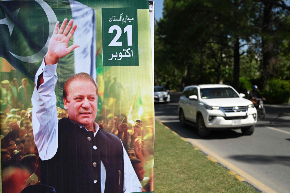 A car drives past a welcoming poster of Pakistan's former prime minister Nawaz Sharif along a street in Islamabad on October 19, 2023, ahead of his return to Pakistan. A Pakistan court granted bail on October 19 to exiled former prime minister and graft convict Nawaz Sharif, removing the threat of arrest when he returns to the country this weekend, his lawyer said. After nearly four years in self-imposed medical exile in the United Kingdom, Sharif is hoping to lead his Pakistan Muslim League-Nawaz (PML-N) party through elections scheduled for January 2024. — AFP pic