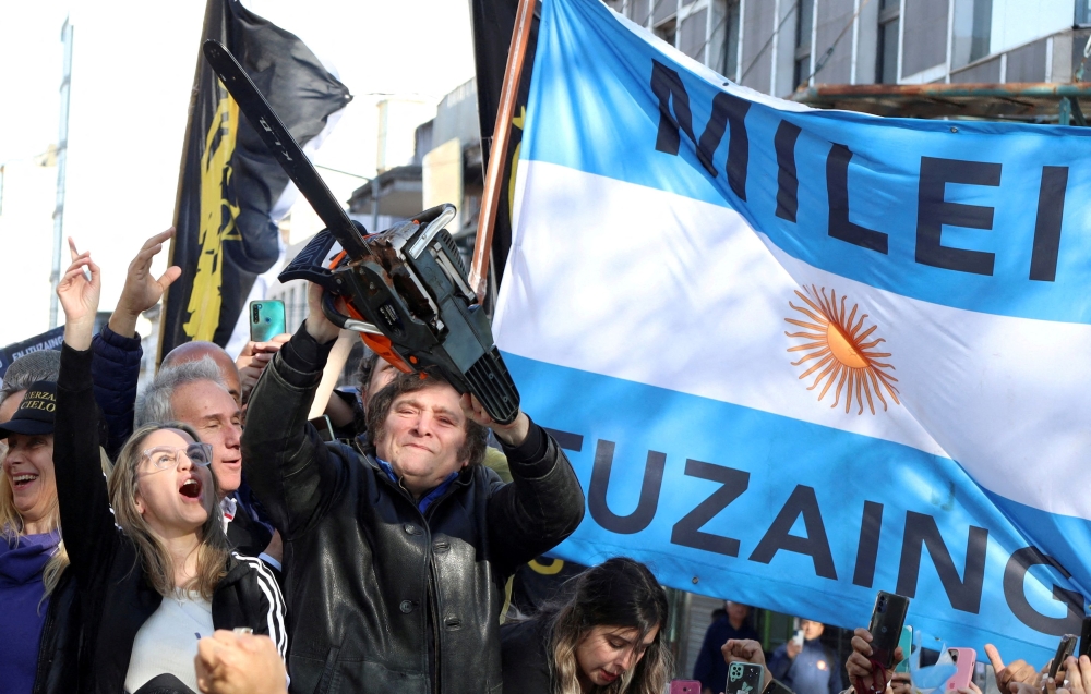 Argentine presidential candidate Javier Milei holds a chainsaw next to Carolina Piparo, candidate for Governor of the Province of Buenos Aires, during a campaign rally, in Buenos Aires September 25, 2023. — Reuters pic