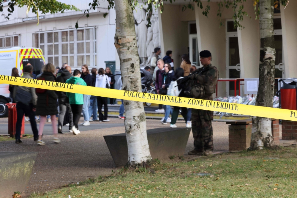 A French military serviceman of ongoing French military operation ‘Operation Sentinelle’ stands guard behind a cordonned-off area the Gambetta high school during its evacuation after a bomb threat in Arras, north-eastern France on October 16, 2023. A 16-year-old was arrested over a bomb hoax outside Paris over a bomb threat emailed to his school. — AFP pic