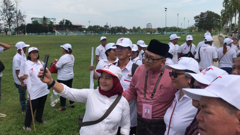 GPS candidate Iskandar Turkee poses for a picture with supporters outside the Bintulu Civic Centre. ― Borneo Post pic
