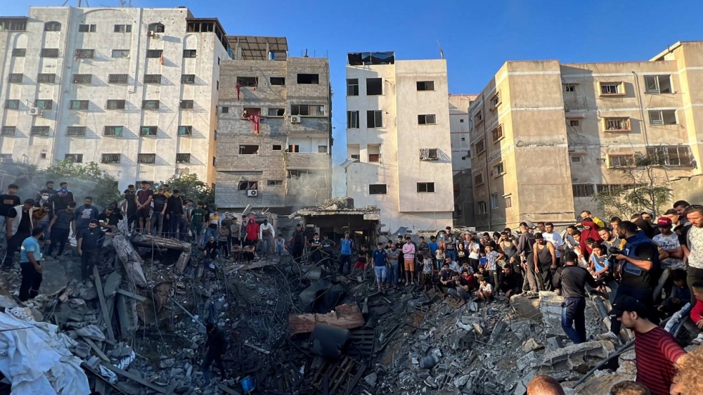 Palestinians gather at the site of an Israeli strike on a house, amid the ongoing conflict between Israel and Palestinian Islamist group Hamas, in Gaza City October 21, 2023. — Reuters pic