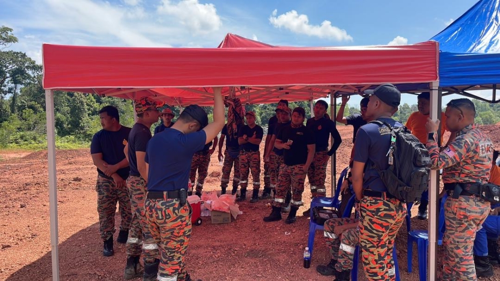 Firemen from the Johor Fire and Rescue Department pack up their makeshift tents that were earlier erected during the peak of the blaze at the Sebana Cove-Punggai bypass in Kota Tinggi October 20, 2023. — Picture courtesy of the Johor Fire and Rescue Department