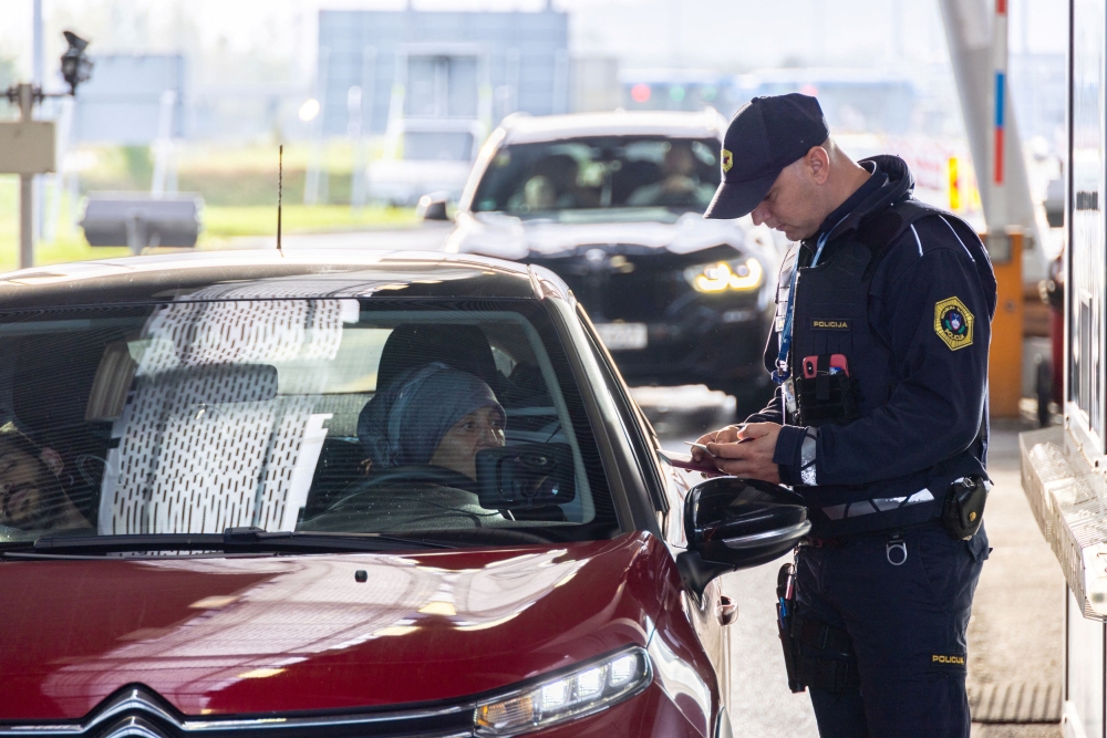 A Police officer inspects documents on border crossing Obrezje, Slovenia, October 21, 2023.— Reuters pic