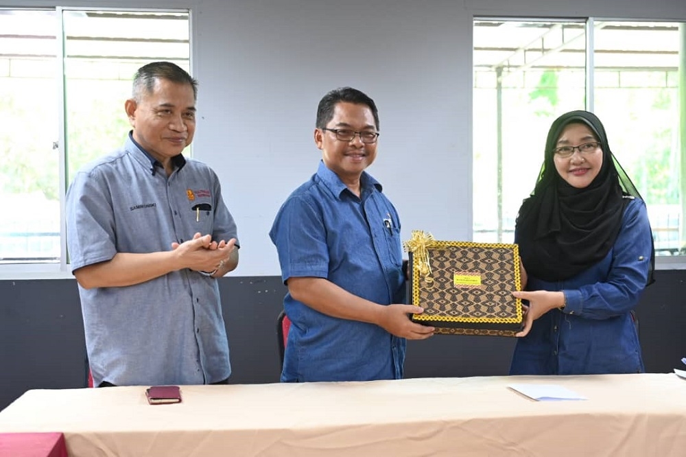 Deputy Human Resource Minister Datuk Mustapha Sakmud (centre) receives a token of appreciation from KKYS Sdn Bhd Board of Directors chairman Datuk Tah Nia Jaman. — Borneo Post pic