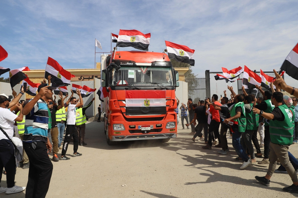 Egyptian aid workers celebrate as an aid truck crosses back into Egypt through the Rafah border crossing with the Gaza Strip on October 21, 2023. — AFP pic