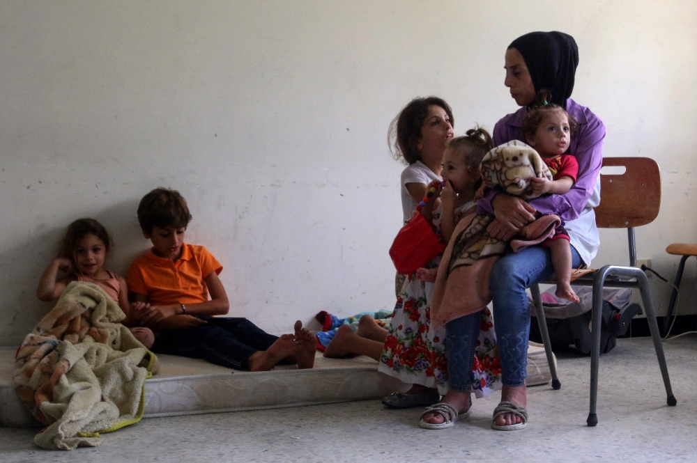 Mustafa al-Sayyid’s wife and children who fled their village in southern Lebanon, sit in a classroom of a school where displaced Lebanese families from villages near the southern border took refuge in Tyre city, on October 19, 2023, as they sought safety further from the intensifying border tensions between Israel on one side and Hezbollah and allied Palestinian factions on the other over Israel's war with Hamas. — AFP pic