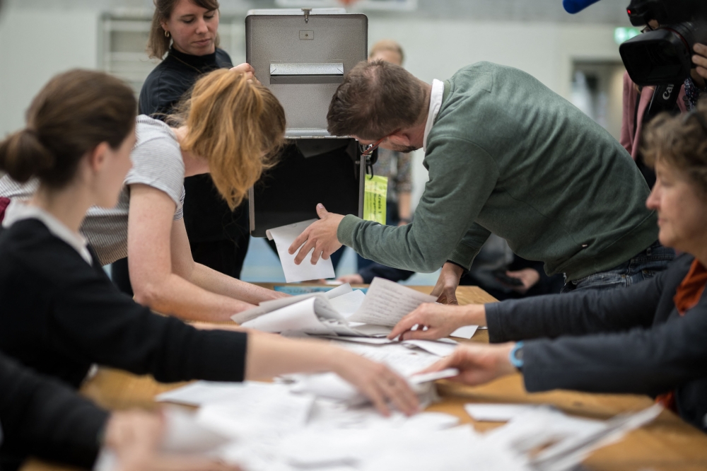 Electoral workers empty a ballot box as counting operations are underway during Swiss federal elections to elect a new Parliament, in Bern, Swiss capital on October 22, 2023. — AFP pic