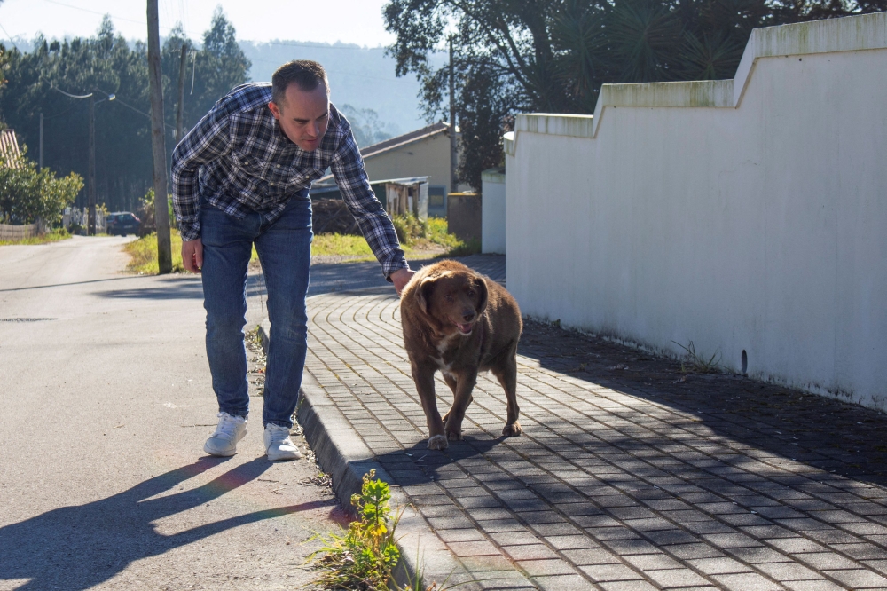 Leonel Costa walks the dog, Bobi, that broke the record for oldest dog ever at 30 years-old, at Conqueiros, in Leiria, Portugal, February 4, 2023. — Reuters pic