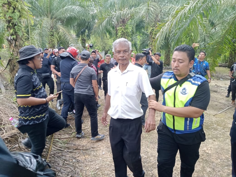 PSM chairman Dr Michael Jeyakumar (centre) is detained by a police officer during a protest in Kanthan, Tambun, on October 24, 2023. — Picture courtesy of PSM
