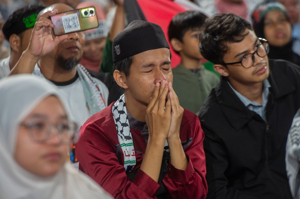 A man reacts after watching a performance at the Solidarity with Palestine rally in the Axiata Arena in Kuala Lumpur October 24, 2023. ― Picture by Shafwan Zaidon