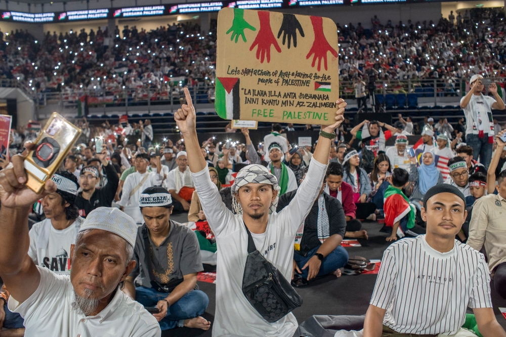 A man holds a placard in support of Palestine at the Axiata Arena in Bukit Jalil, Kuala Lumpur on October 24, 2023. ― Picture by Shafwan Zaidon