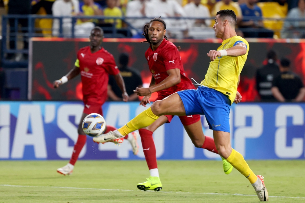 Duhail’s Portuguese defender Ruben Semedo (left) eyes Nassr’s Portuguese forward Cristiano Ronaldo as he plays the ball during the AFC Champions League Group E football match between Saudi’s al-Nassr and Qatar’s al-Duhail at the King Saud University Stadium in Riyadh October 24, 2023. — AFP pic