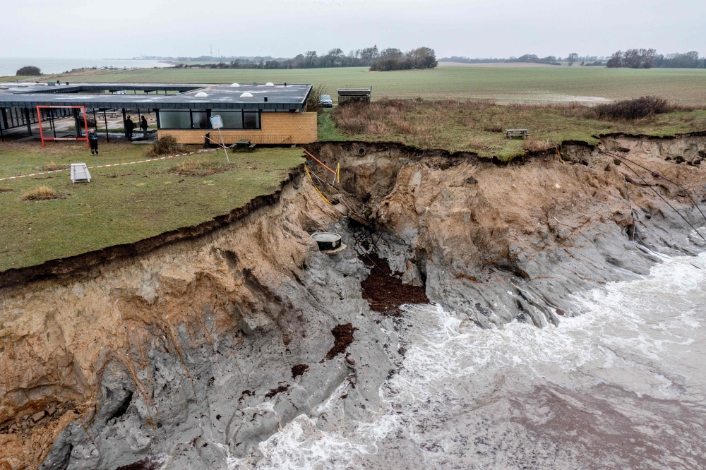 An aerial view taken with a drone on October 21, 2023 shows a crashed down cliff and damages at the marine station in Gedser on the southern tip on Falster, Denmark, after the area was affected by a heavy storm. — AFP pic