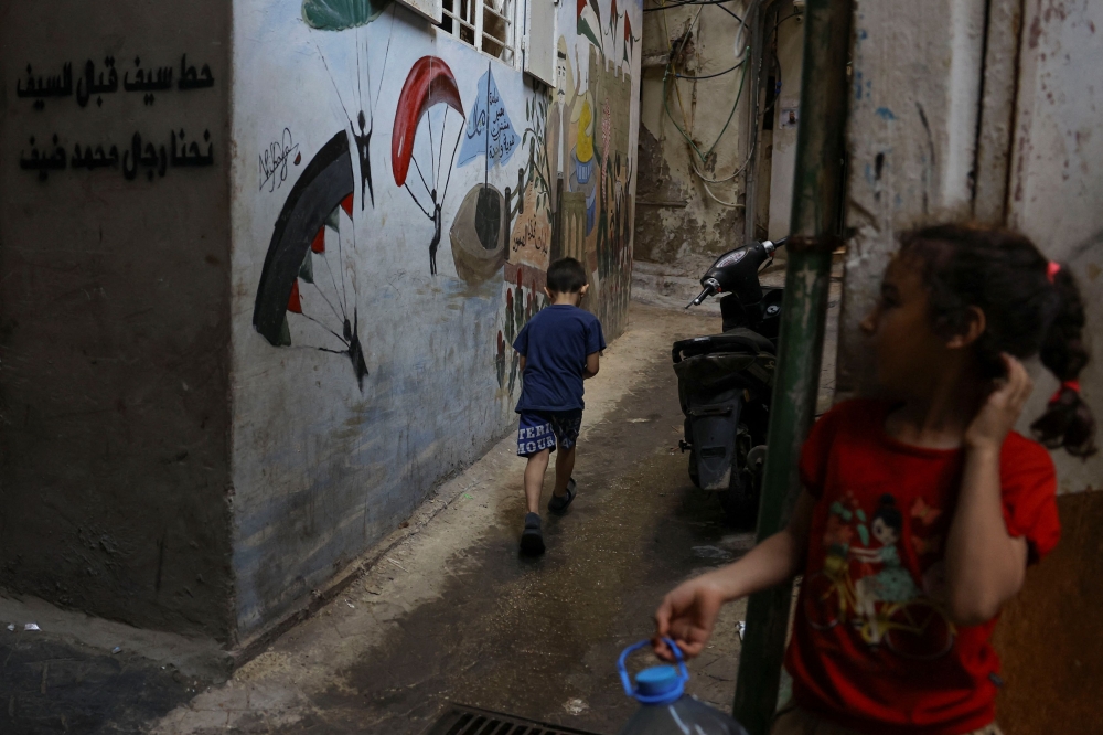 A girl stands as a boy walks in Bourj al-Barajneh Refugee Camp in Beirut, Lebanon, October 25, 2023. — Reuters pic