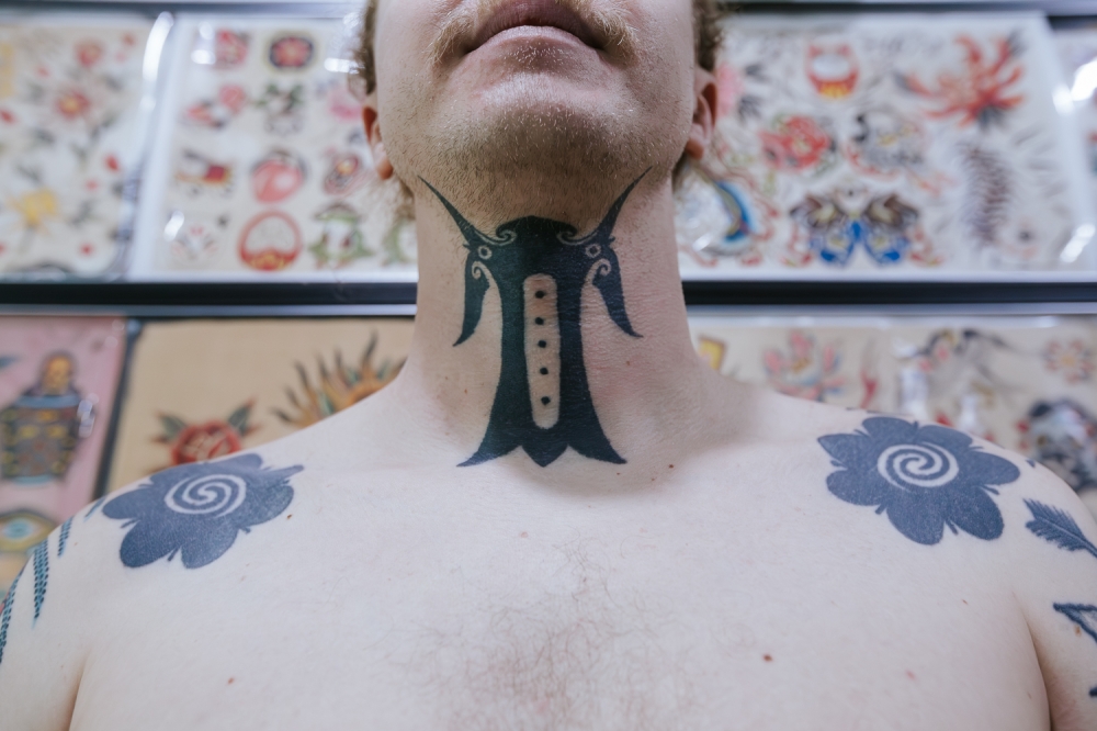 An Iban man is required to get an 'ukir rekong' (throat tattoo) or 'bunga terung' tattoos on his shoulders first before pursuing other motifs.  — Picture by Raymond Manuel