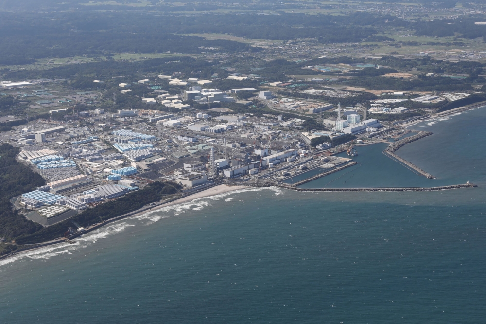This aerial picture shows storage tanks (L) used for storing treated water at TEPCO's crippled Fukushima Daiichi Nuclear Power Plant in Okuma, Fukushima prefecture on August 24, 2023. — AFP pic
