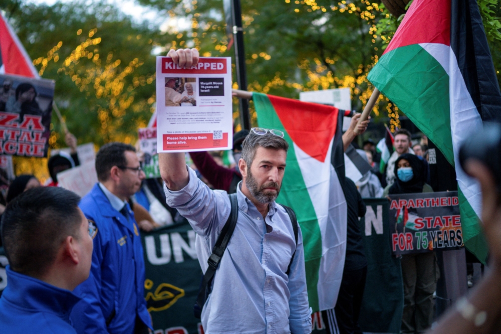A pro-Israel demonstrator holds a picture of a person believed to be held hostage by Hamas militants during a pro-Palestinian demonstration, amid the ongoing conflict between Israel and Hamas, on Wall St outside the New York Stock Exchange, in New York City October 26, 2023.— Reuters pic