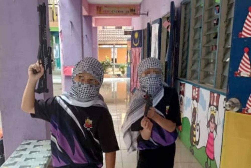 A viral photo showing two primary students hoisting firearms as part of the Palestine Solidarity Week event in schools.
