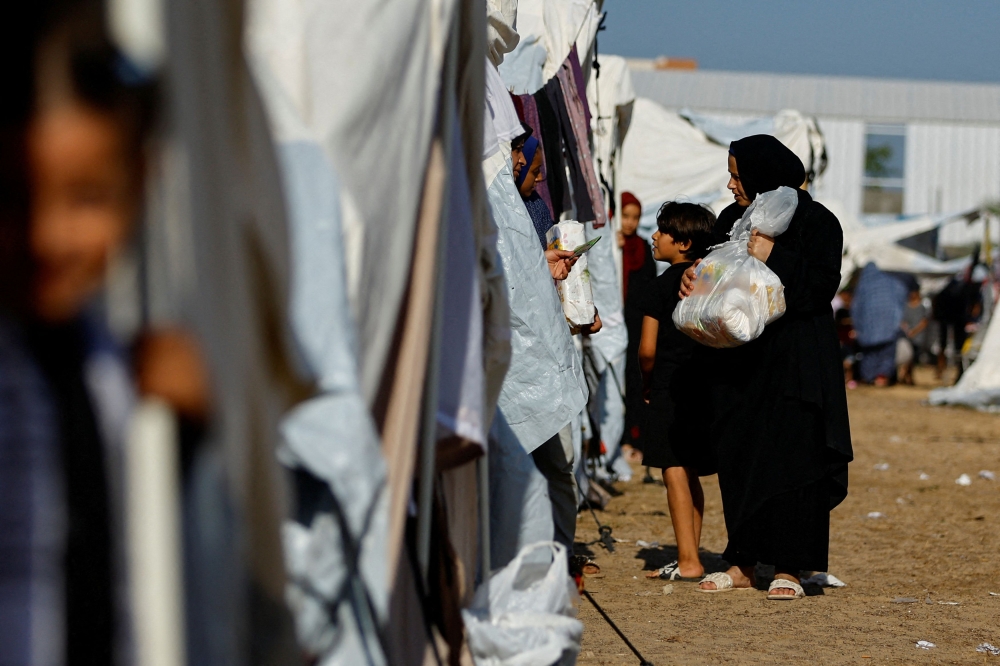 Palestinians, who fled their houses amid Israeli strikes, take shelter at a tent camp at a United Nations-run centre, after Israel's call for more than 1 million civilians in northern Gaza to move south, in Khan Younis in the southern Gaza Strip, October 26, 2023. — Reuters pic