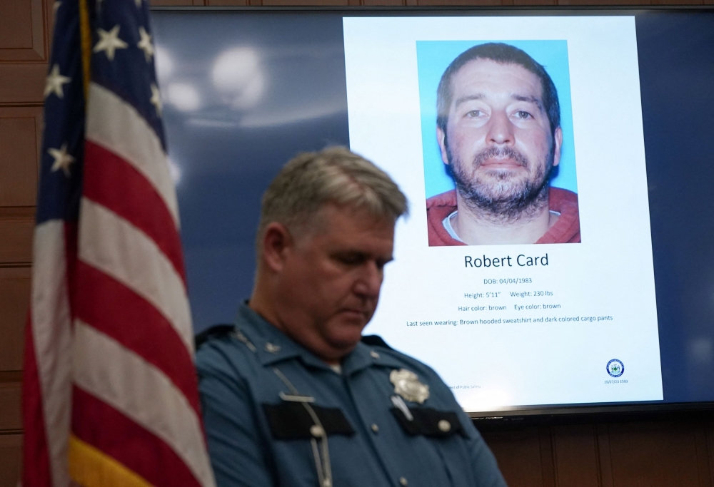 A police officer stands next to a screen displaying the picture of the suspected shooter, during a press conference following the deadly mass shooting, at City Hall in Lewiston, Maine October 27, 2023. ― Reuters pic