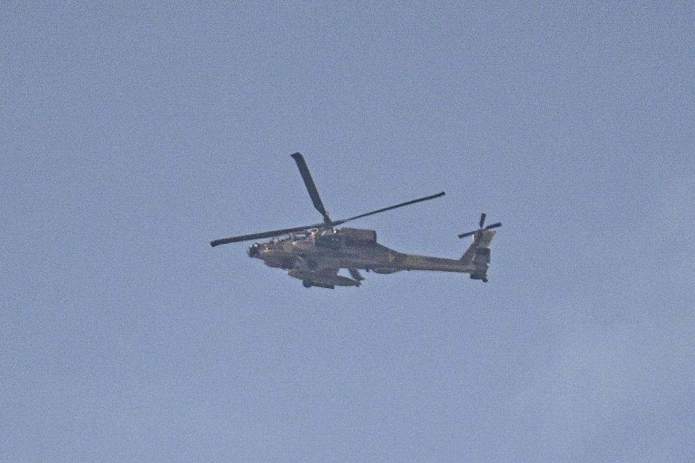 An Israeli air force AH-65 Apache attack helicopter flies near the border with the Gaza Strip close to Israel's southern city of Ashkeon on October 28, 2023, amid the ongoing battles between Israel and the Palestinian group Hamas. ― AFP pic