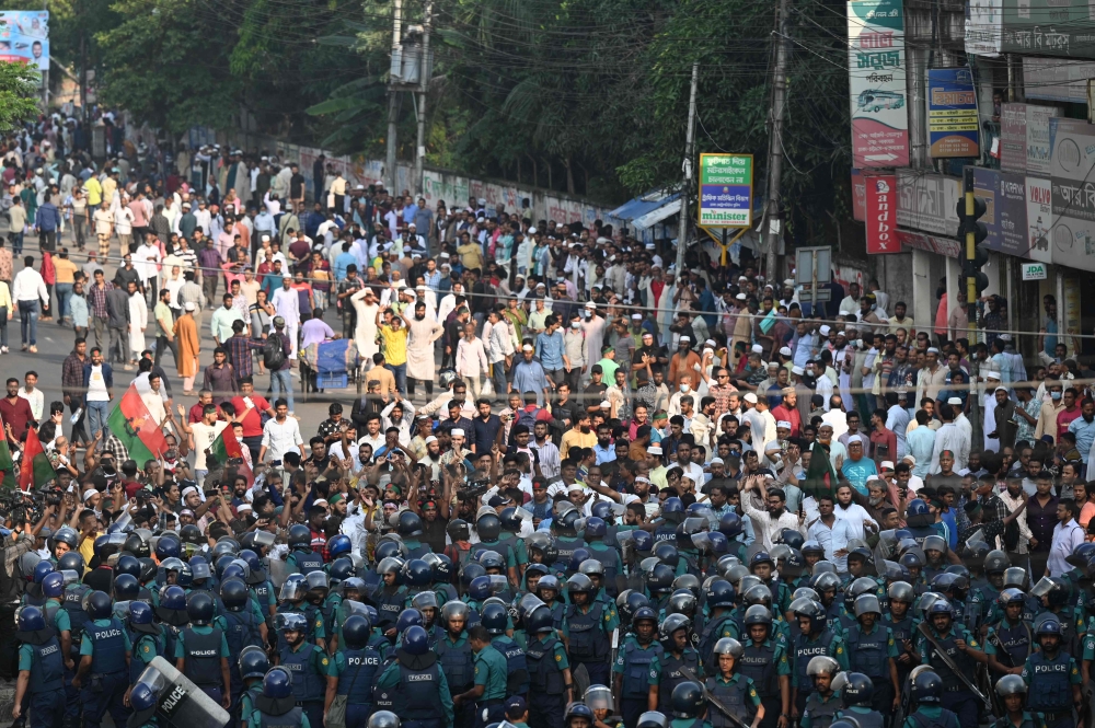 Police (front) stand guard in front of Bangladesh Nationalist party (BNP) activists during a rally demanding the resignation of the current government, the establishment of a non-partisan neutral government and the release of BNP chairperson Begum Khaleda Zia, in Dhaka on October 28, 2023. — AFP pic