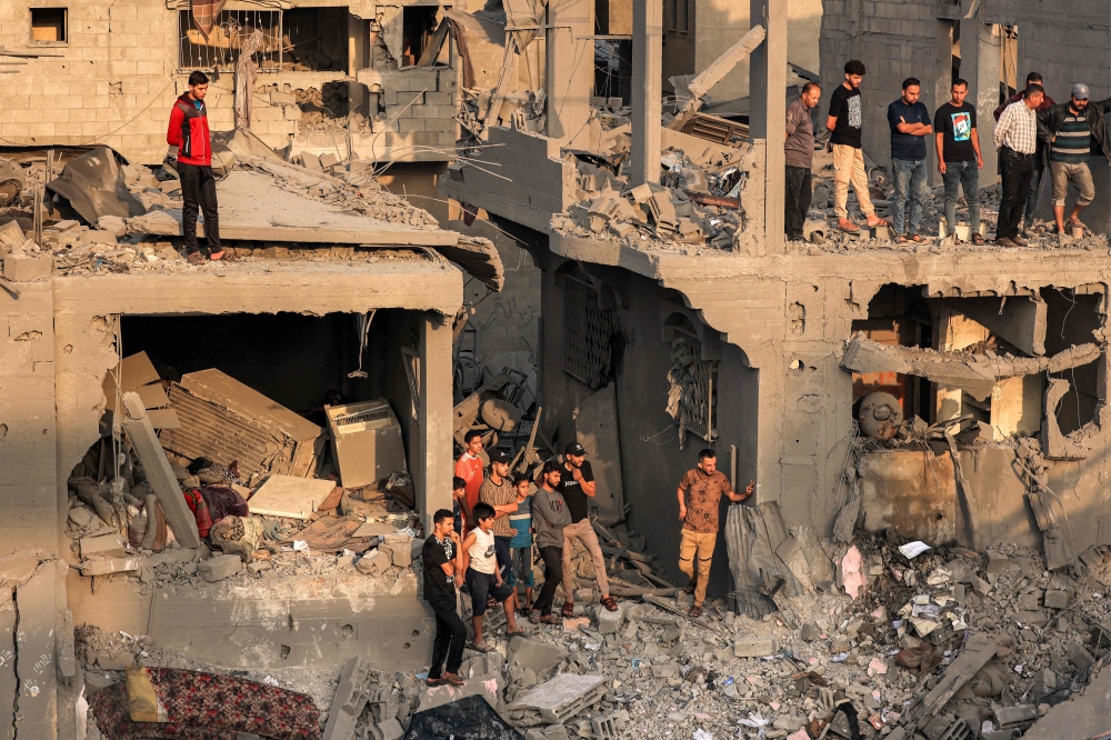 File photo of people searching for survivors and the bodies of victims through buildings that were destroyed during Israeli bombardment, in Khan Yunis in the southern Gaza Strip on October 25, 2023, amid the ongoing battles between Israel and the Palestinian group Hamas. — AFP pic