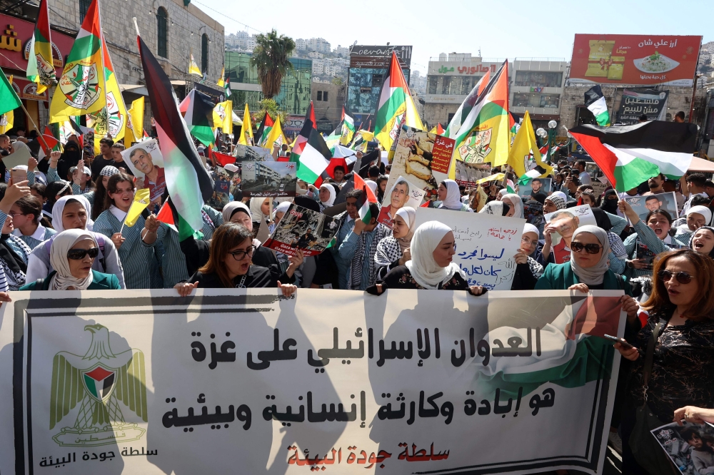 People waving Palestinian and Fatah flags deploy a banner as they march in support of the people of the Gaza Strip in the occupied West bank city of Nablus on October 26, 2026, amid ongoing battles between Israel and the Palestinian Hamas movement. — AFP pic