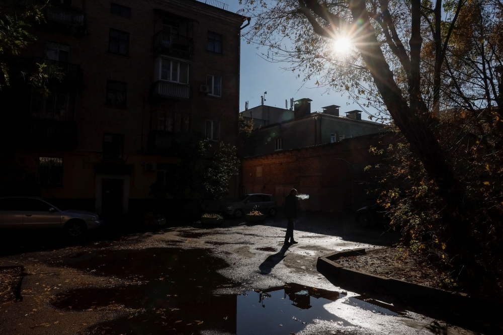 A man smokes in a yard during a warm autumn day, amid Russia’s attack on Ukraine, in central Kyiv, Ukraine October 27, 2023. — Reuters pic