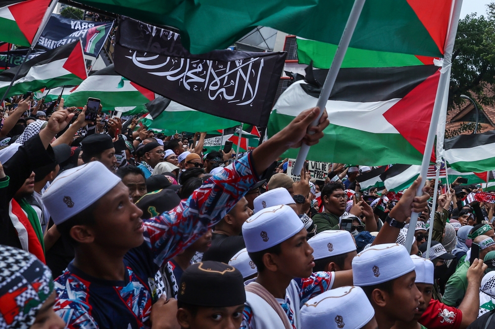 People hold the Palestine flag and banners during the Solidarity with Palestine rally in Kuala Lumpur October 28, 2023. — Bernama pic