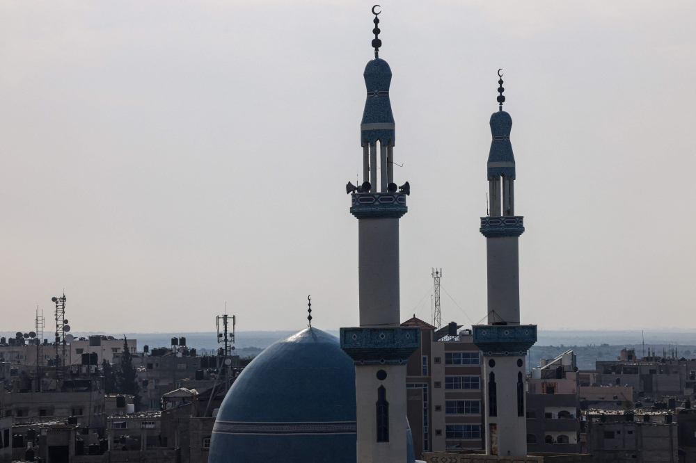 An antenna of a communications tower that relays phone and internet signals is pictured between the minarets of a mosque in Rafah, in the southern Gaza Strip on October 28 , 2023, amid the ongoing battles between Israel and the Palestinian group Hamas. — AFP pic
