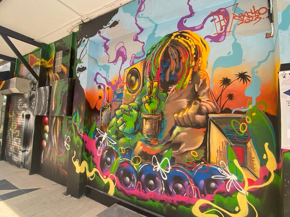 Crig’s piece features a Rastafarian and an orangutan with coffee beans on the adjacent wall.