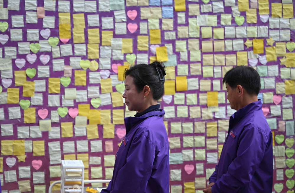 Relatives of Itaewon crush victims look at notes of support during an unveiling ceremony of a memorial street marker to remember the victims of the October 29, 2022 crowd crush that killed more than 150 people during Halloween celebrations. — AFP pic