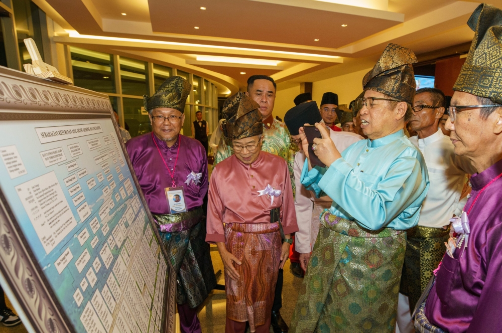 Abang Johari is seen taking snapshot of the Gedong Malay nobles’ family tree on display prior to the dinner. Also seen is Naroden (second left). — Picture from Sarawak Public Communications Unit