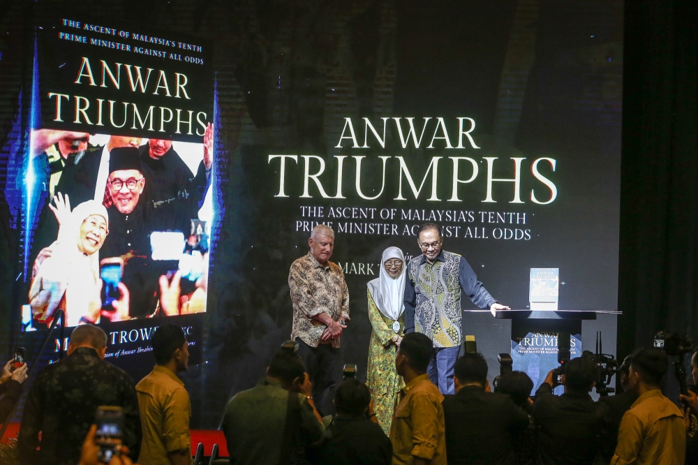 Prime Minister Datuk Seri Anwar Ibrahim, Datuk Seri Dr Wan Azizah Wan Ismail and Author Mark Trowell (left) are seen during the book launch for ‘Anwar Triumphs’ at Kuala Lumpur Convention Centre October 29, 2023. — Picture by Yusof Mat Isa