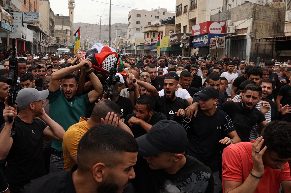 Mourners carry the body of Naem Farran, one of three Palestinians killed in an Israeli raid, during his funeral in the Askar refugee camp near the occupied West Bank city of Nablus, on October 29, 2023. The Palestinian health ministry said three people aged 29 to 31 were shot dead by Israeli forces at dawn, with the incidents taking place in Beit Rima, northwest of Ramallah, in Nablus’s Askar refugee camp and in Tubas, a town further north. — AFP pic